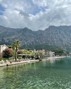 the water is crystal green and clear with mountains in the background at this beach resort