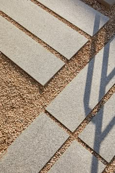 the shadow of a person's hand is cast on some concrete blocks and gravel