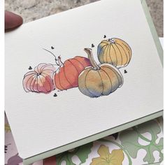 a hand holding up a card with watercolor pumpkins on the front and back