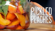 pickled peaches in a glass jar on a table with the words pickled peaches