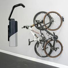 a bike mounted to the side of a wall next to a cell phone and camera