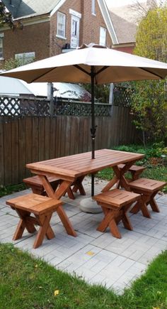 a wooden picnic table with an umbrella over it