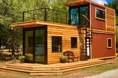 a house made out of shipping containers with stairs to the upper floor and second story