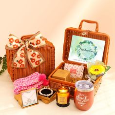 a wicker basket filled with lots of different items next to a greeting card and candle