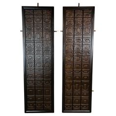 two large wooden doors with decorative designs on the front and back sides, one is black