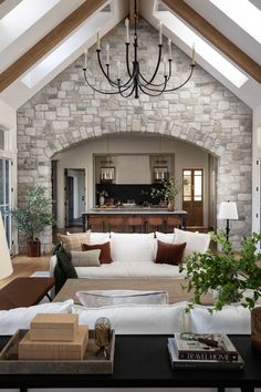 a living room filled with lots of furniture and a chandelier hanging from the ceiling