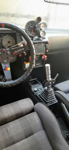 the interior of a car with steering wheel and gauges