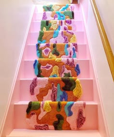 the carpeted stairs are lined with colorful rugs on them, and they're painted bright pink