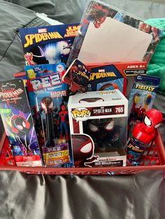 a red basket filled with toys on top of a bed