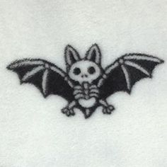 a black and white image of a bat with skull on it's back side