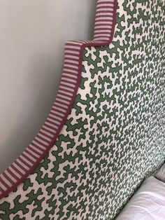 an upholstered headboard with green and white designs on it's sides