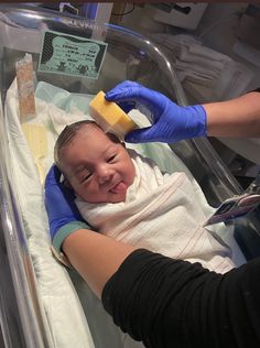 a baby in a hospital bed being washed with soap and scrubbing it's head