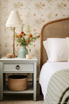 a bedroom with flowers on the wall next to a bed and nightstand in front of it