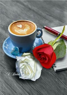 a cup of coffee and a rose on a table