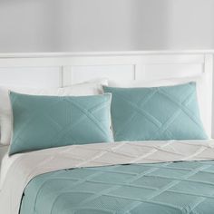 a bed with blue and white comforters in a bedroom