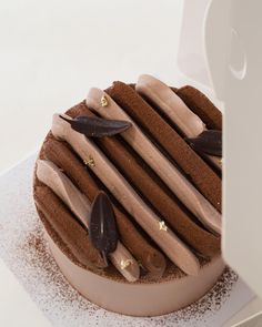 a chocolate cake sitting on top of a white plate covered in frosting and toppings