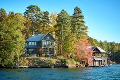 a house sitting on top of a lake surrounded by trees