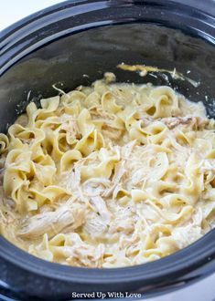 the crock pot is filled with pasta and meat