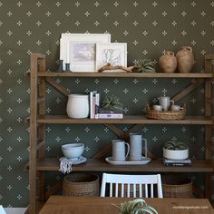 a wooden table sitting next to a shelf filled with pots and bowls on top of it