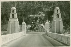 an old black and white photo of a bridge with two towers on each side that reads riverside