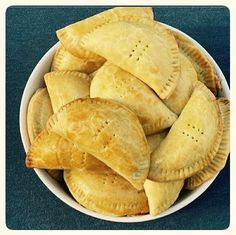 a bowl full of pita chips on a blue tablecloth with a white border