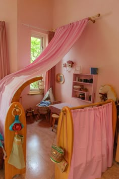 a child's bedroom decorated in pink and yellow with an arch over the bed