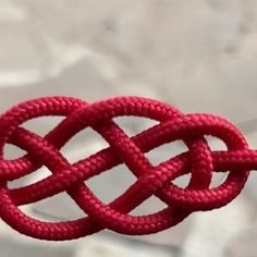 a red knot hanging from the side of a rope