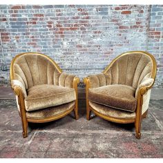 two chairs sitting next to each other in front of a brick wall