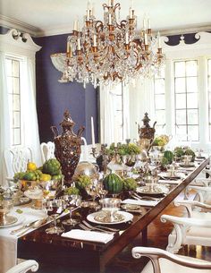 the dining room is set for dinner with many plates and place settings on the table