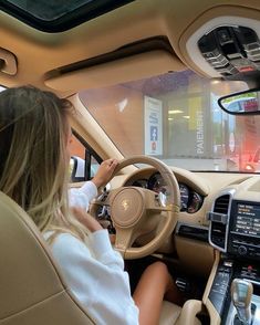 a woman sitting in the driver's seat of a car