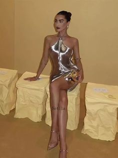 a woman in a silver dress sitting on a table