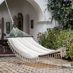 a white hammock hanging in front of a house