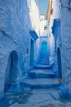 an alley way with blue walls and steps