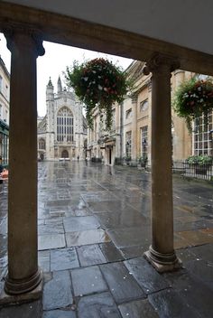 some flowers are hanging on the pillars in front of buildings