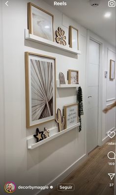 a hallway with white walls and pictures on the wall, along with wooden flooring