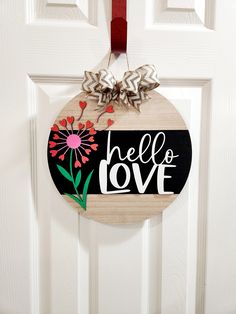 a wooden sign that says hello love hanging on a door with a red ribbon and bow