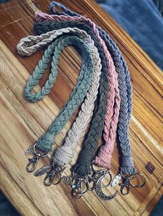 several different colored knitted lanyards on a wooden table