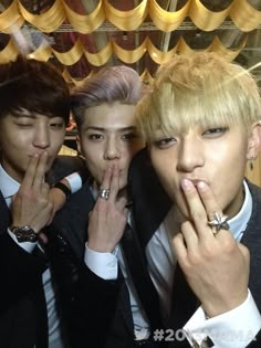 three young men with their fingers in their mouths