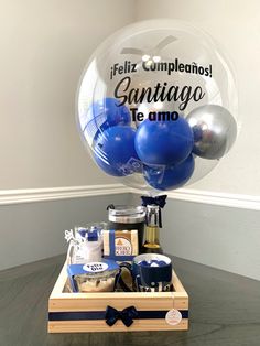 a box with some blue and silver items in it that says feliz cumpleanos santiago te amo