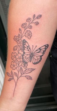 a woman's arm with a butterfly and flowers on it