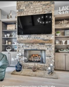 a living room with a stone fireplace and entertainment center