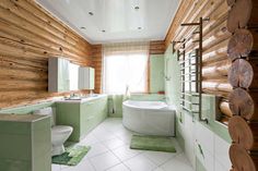 a bathroom with green and white decor, including a large tub in the middle of the room