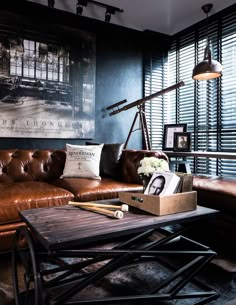 a living room with leather couches and pictures on the wall