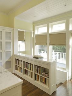 a bed sitting in a bedroom next to a book shelf filled with lots of books