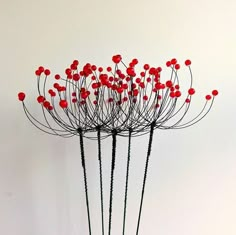 a bunch of red flowers sitting on top of a white table next to a wall