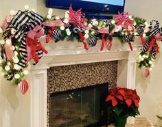 a fireplace decorated for christmas with poinsettis and ribbons on the mantel