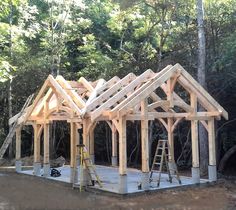 a house being built in the woods with wood framing and roof trusss on it