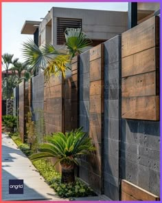 a wooden fence next to a building with palm trees