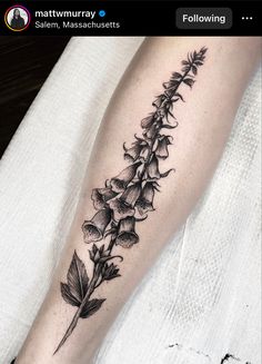 a black and white photo of a flower on the leg, with an arrow in the middle