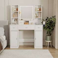 a white desk with a mirror and shelves on it in front of a window next to a couch